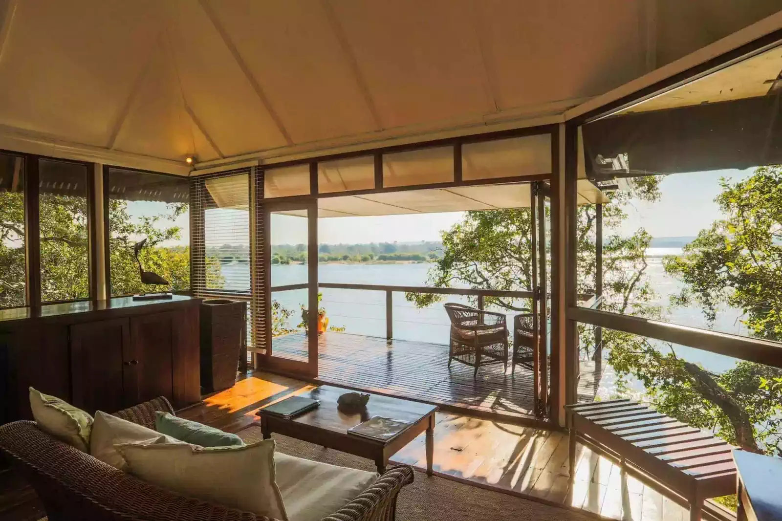 Interior of lounge overlooking river in River Club lodge in Livingstone
