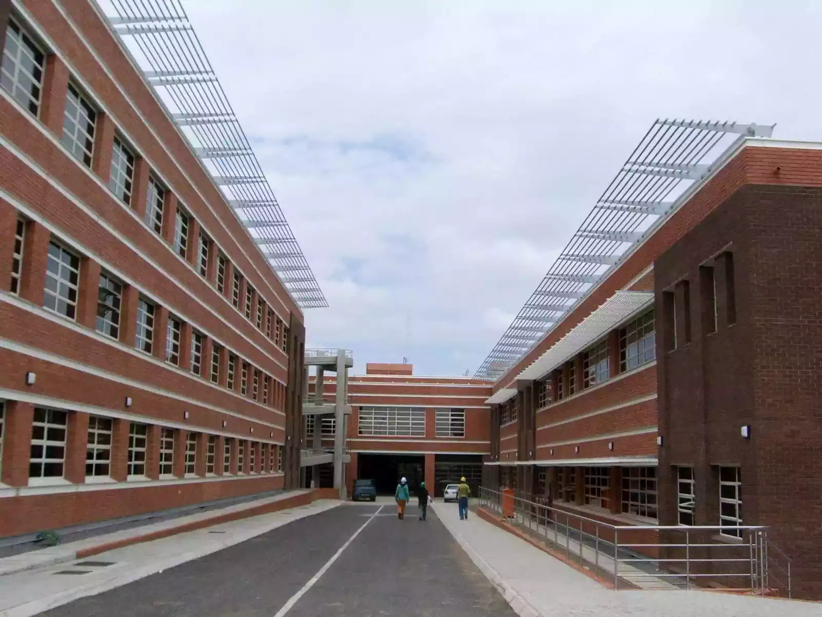Parallel facebrick buildings with louvres for shade in medical facility designed by architect