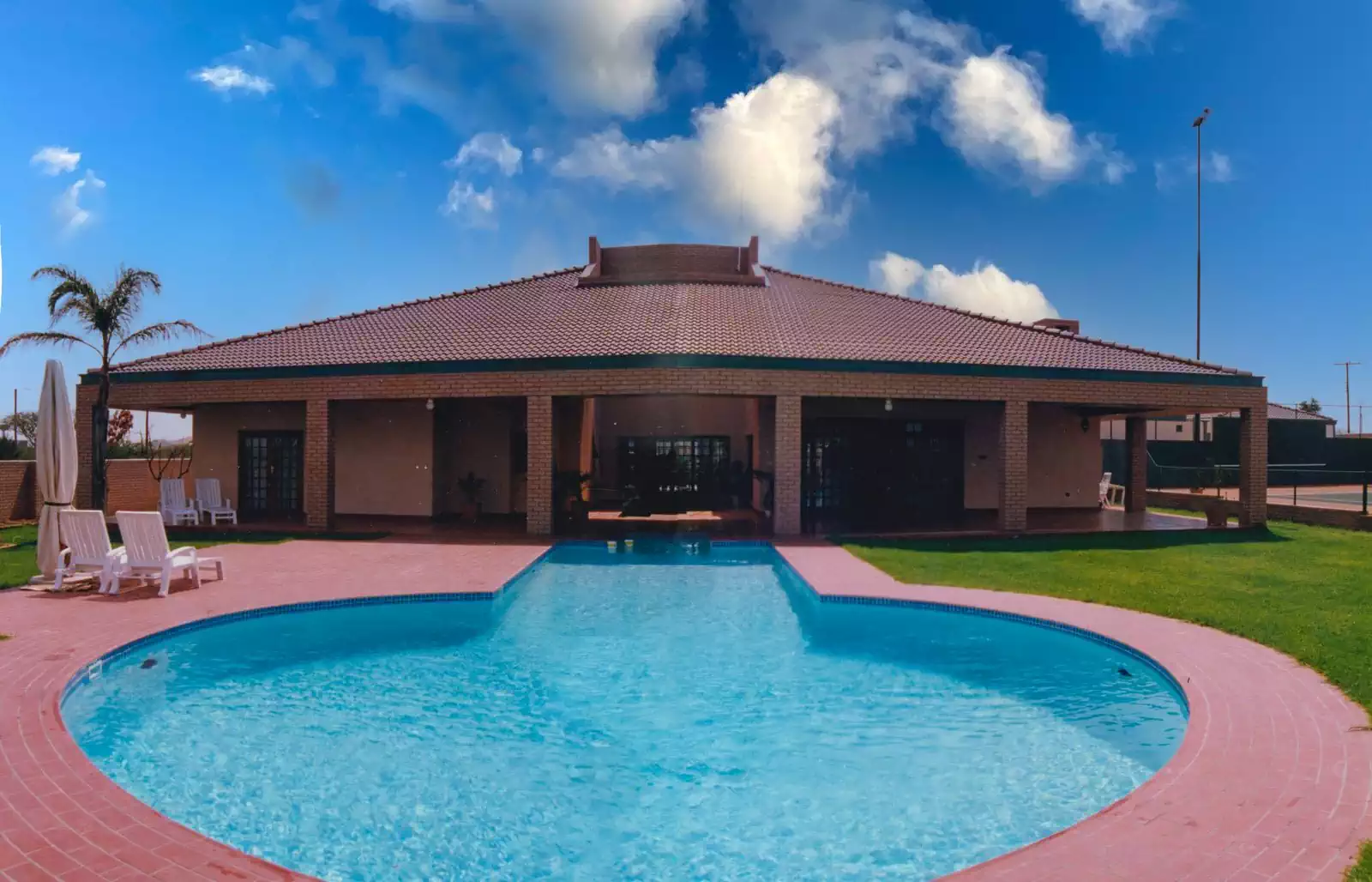 Symmetrical contemporary face-brick house with wooden trusses designed by Zimbabwe architect