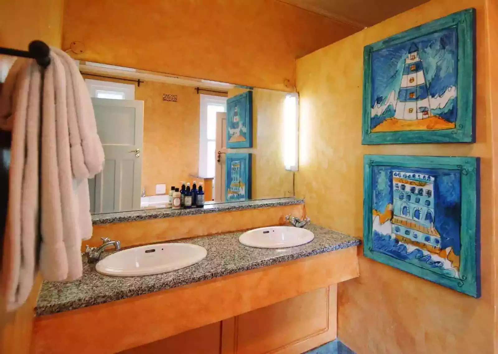 Interior design detail of mediterranean bathroom with his and hers sinks and yellow walls 