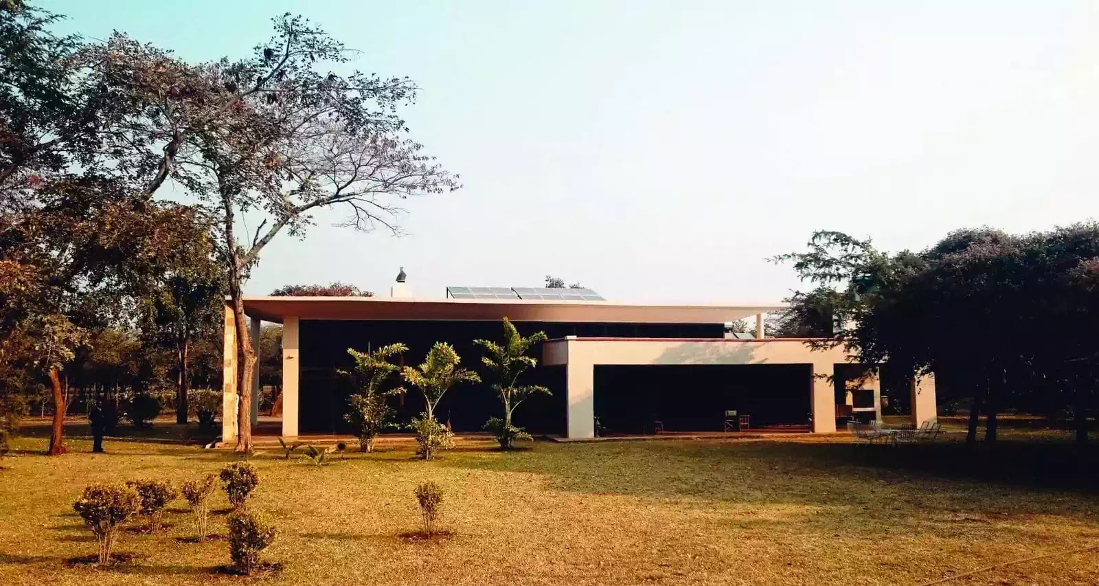 Sleek minimalist modern house design with large horizontal roofs and big overhangs covering veranda. Luxury house in Lusaka, Zambia by local architect