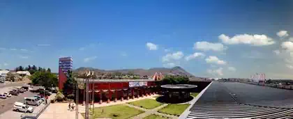 Roof view of airy shopping centre with tower and greenery