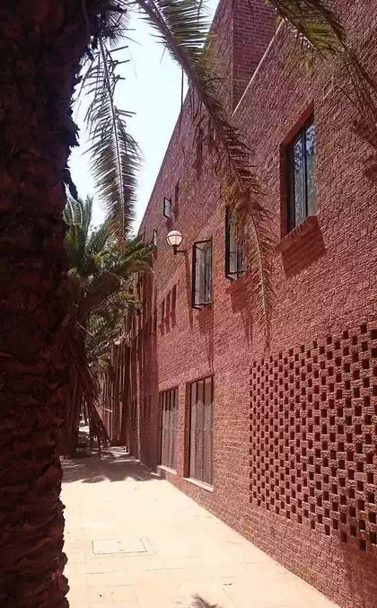 Facebrick textured wall with ventilation and trees