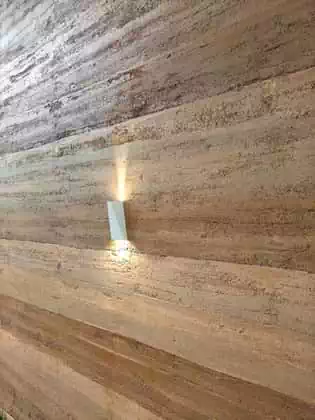Detail of light fitting on rammed earth wall with colour banding in Zimbabwe