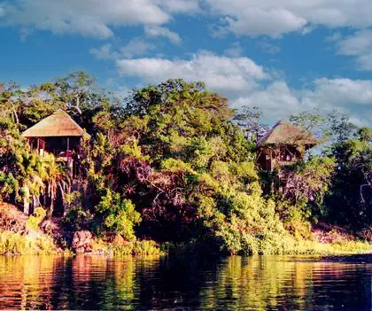 Spectacular aerial view of Zambezi river and lodge bungalows within dense vegetation designed by Harare architect