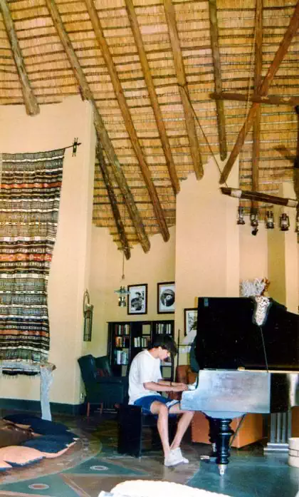 Traditional wooden gumpole structure and thatched roof in earthy interiors lodge