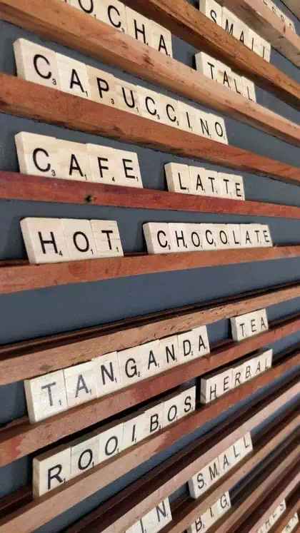 Fun coffee shop modern interior design with wooden cladding and wooden elements by architect in Harare