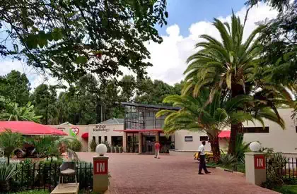 Modern Glass entrance to hospital building amongst trees in Harare