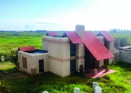 Mediterranean house with large tiled roof in Beira, Mozambique. Vertical glass walls on side of veranda