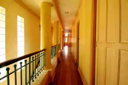 Interior design detail of corridor in tuscan house with round columns and wrought iron railing by architect from Harare