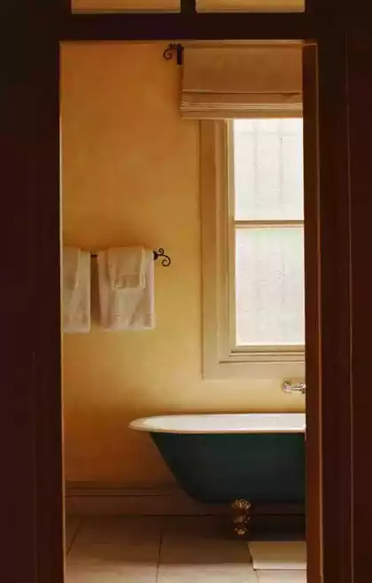 Cast-iron bath and sash-window detail in mediterranean bathroom. Interior design by Pantic Architect