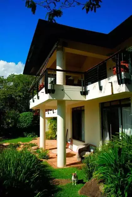 Overhanging balcony detail with large overhanging roof immersed in vegetation in Thetford estate in Harare