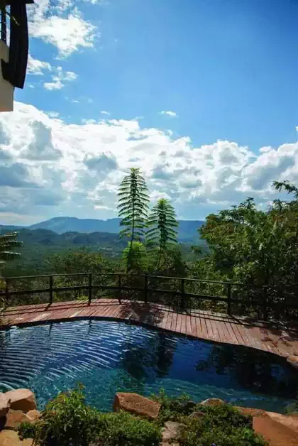 Spectacular view on Mazowe hills overlooking pool deck in luxurious modern villa by Harare architectural firm