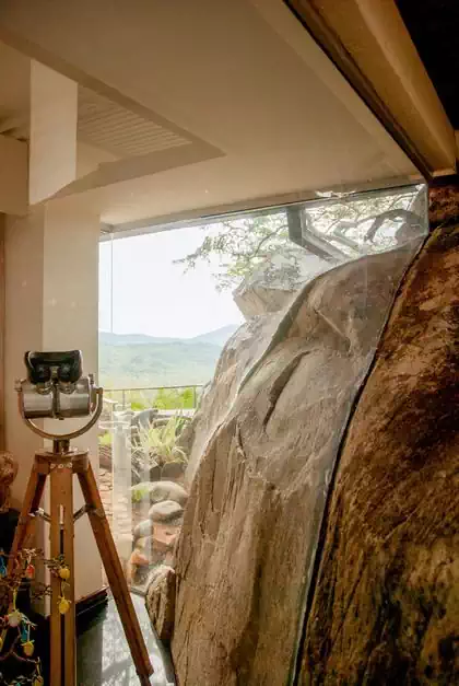 Amazing rock within house among tree canopies and treetops. House interior design by harare architect