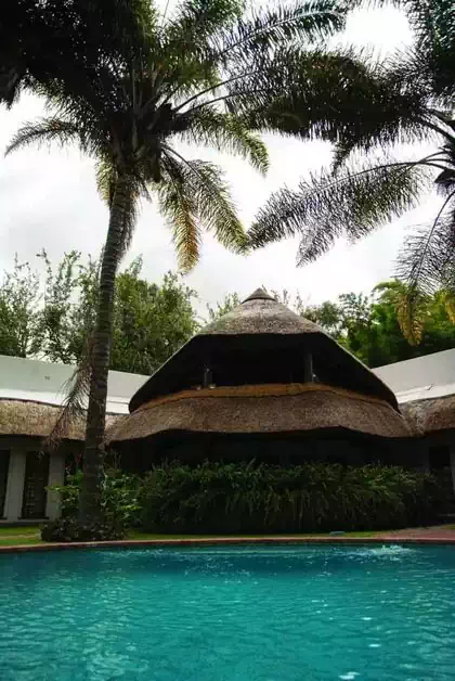 Circular pool in front of Thatched tower covering veranda and upstairs gallery. Modern home design by Pantic Architects