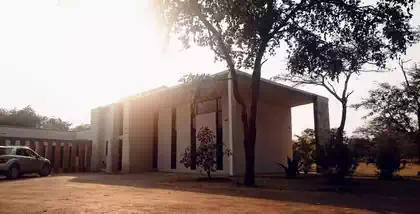 Imposing modern minimalist house with narrow vertical windows and large roof overhangs to provide shade and protection. House design by Harare architect